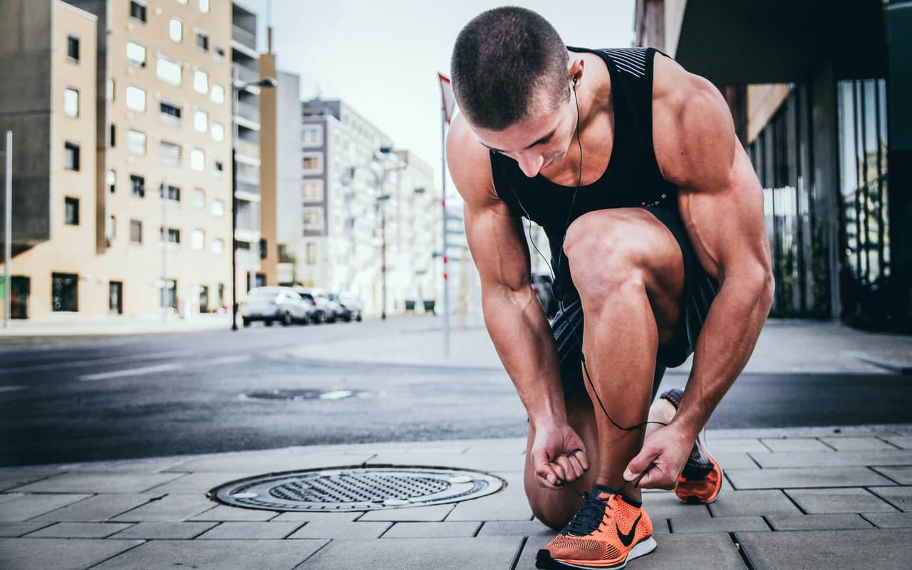 Ein junger Mann kniet auf dem Bordstein und schnürt sich die Schuhe für eine Runde Jogging. Wir zeigen dir, wie Sport Bargfrede mit dem Xentral ERP zurück auf die Überholspur findet.