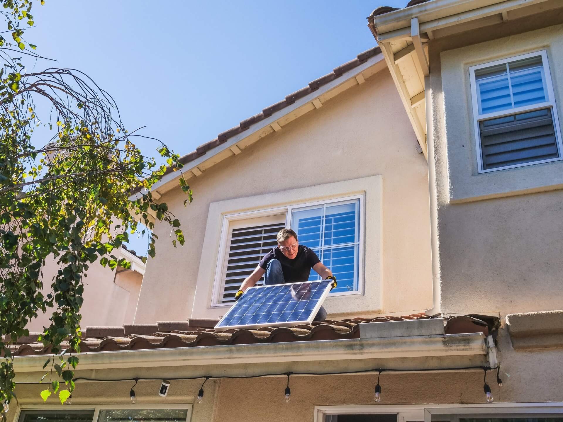 Techniker installiert Solarpanel auf dem Dach eines Wohnhauses.